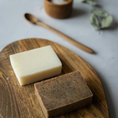 From above of aromatic natural handmade soap near timber spoon and scrub with salt